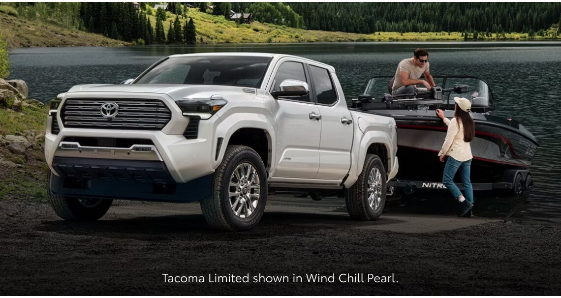 Front three-quarter view of a Toyota Tacoma Limited in Wind Chill parked while towing a motorboard.