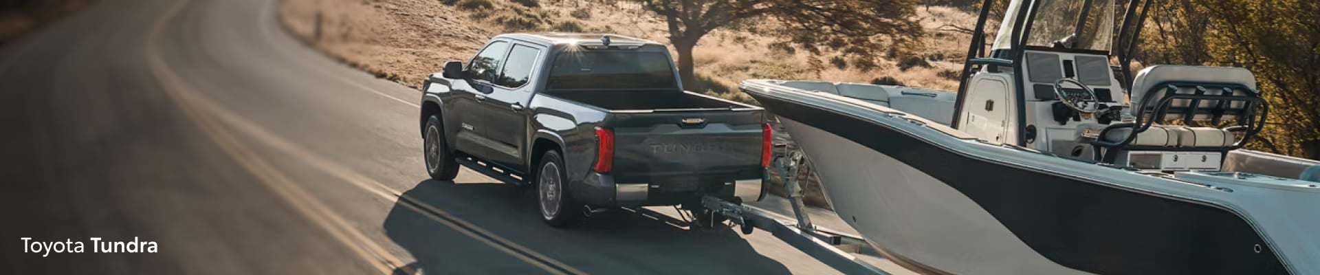 Toyota Tundra towing a boat on a road.